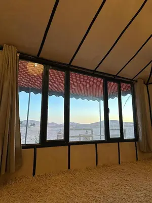 a window in a room with a view of the ocean at Camp Luxueux en plein désert de Merzouga in Merzouga