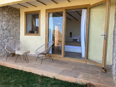 a patio with two chairs and a sliding glass door at Dar El Mandar - Ferme & Table d'Hôte Berbère in Bhalil