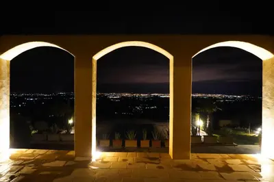 a view of a city from a balcony at night at Dar El Mandar - Ferme & Table d'Hôte Berbère in Bhalil