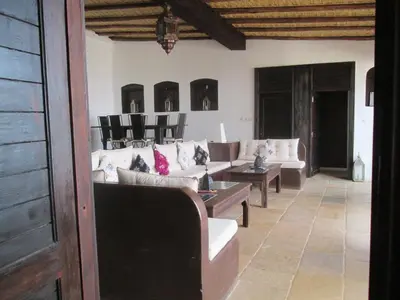 a living room with couches and a table and chairs at Dar El Mandar - Ferme & Table d'Hôte Berbère in Bhalil