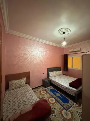 two beds in a room with pink walls at Résidence MARHABA in Ouarzazate