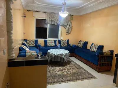 a living room with a blue couch and a table at Wafae in Meknès
