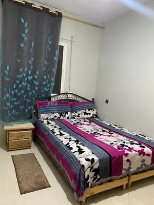 a bedroom with a bed with a black and white comforter at Wafae in Meknès