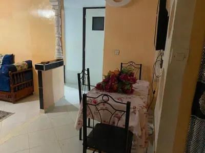 a dining room table with a flower arrangement on it at Wafae in Meknès