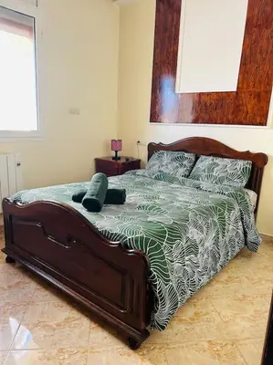a bedroom with a bed with a green and white comforter at Zen environnement Horse riding in Zaouia dʼIfrane