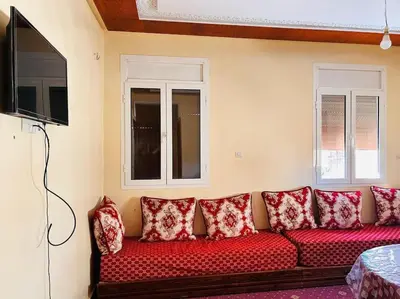 a red couch with red pillows in a living room at Coquet F2 Jnane el Atlas Ifrane in Zaouia dʼIfrane