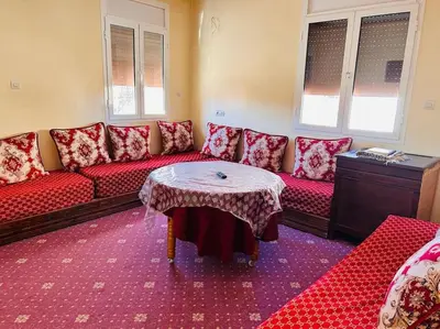 a living room with a red couch and a table at Coquet F2 Jnane el Atlas Ifrane in Zaouia dʼIfrane