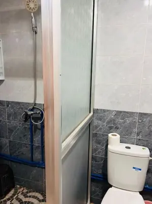 a bathroom with a shower and a white toilet at Coquet F2 Jnane el Atlas Ifrane in Zaouia dʼIfrane