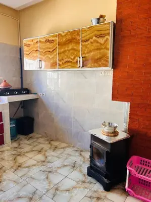 a kitchen with a stove in the corner of a room at Coquet F2 Jnane el Atlas Ifrane in Zaouia dʼIfrane
