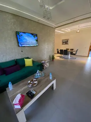 a living room with a green couch and a table at charmante villa de luxe à Marrakech in Marrakech