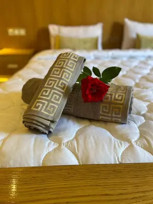 two pillows and a rose on a bed at charmante villa de luxe à Marrakech in Marrakech