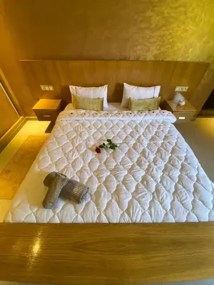 a large white bed with two pillows on it at charmante villa de luxe à Marrakech in Marrakech