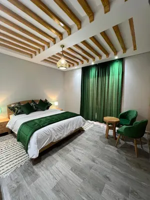 a bedroom with a large bed and green curtains at Ferme d'hôtes Bladna Garden in Meknès