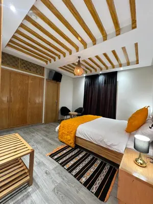 a bedroom with a king sized bed and a table at Ferme d'hôtes Bladna Garden in Meknès