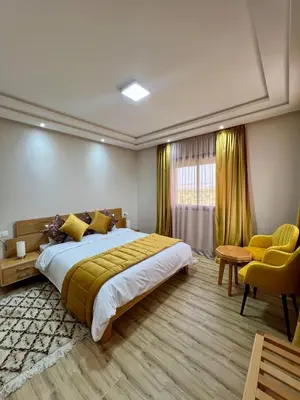 a bedroom with a large bed and yellow curtains at Ferme d'hôtes Bladna Garden in Meknès