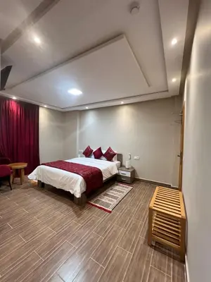 a bedroom with a large bed and a red curtain at Ferme d'hôtes Bladna Garden in Meknès