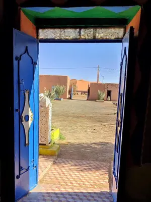 an open door with a view of a desert area at Sahara Apartements in Merzouga