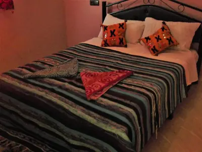a large bed with pillows on top of it at Sahara Apartements in Merzouga