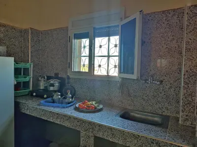 a kitchen counter with a sink and a window at Sahara Apartements in Merzouga