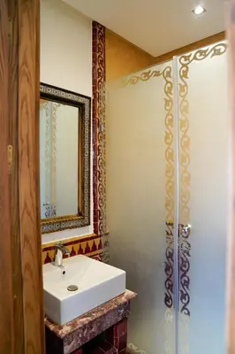 a bathroom with a white sink and a mirror at Palais Volteras in Marrakech
