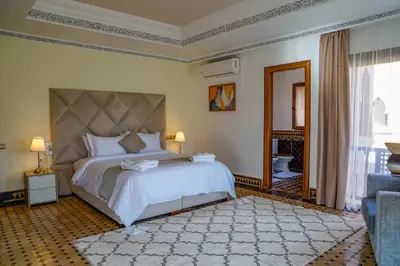 a bedroom with a large bed and a large window at Palais Volteras in Marrakech