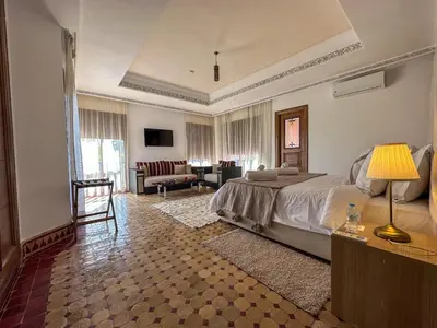 a bedroom with a bed and a living room at Palais Volteras in Marrakech
