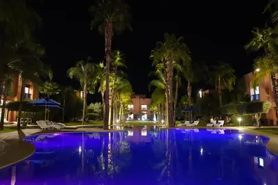 a swimming pool at night with purple lights at Palais Volteras in Marrakech