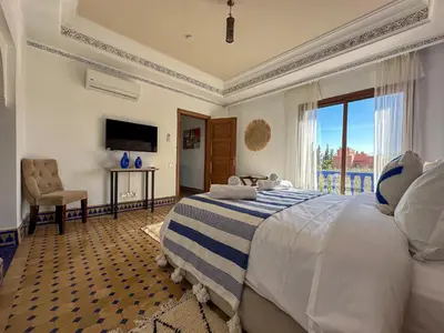 a bedroom with a large bed and a balcony at Palais Volteras in Marrakech