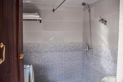 a bathroom with a shower with a glass door at Hôtel Restaurant Ali in Midelt