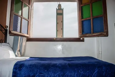 a bedroom with a bed and a window with a lighthouse at Hôtel Restaurant Ali in Midelt
