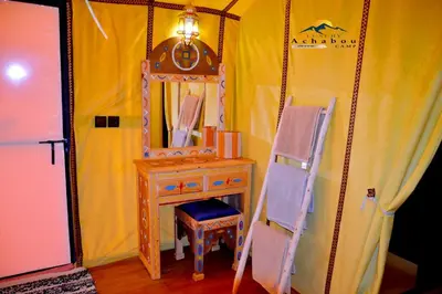 a wooden dressing table with a mirror and a chair at Sahara Luxury Camp - Nuit de rêve dans le désert de Merzouga ! in Merzouga