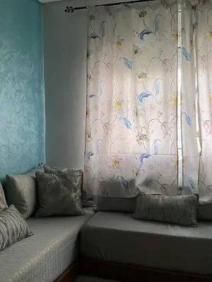 a bedroom with a window with a curtain with blue butterflies at Appart propre et bien situé d in Fès