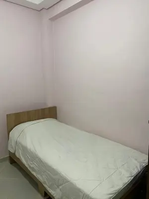 a bed in a room with white walls at Appart propre et bien situé d in Fès