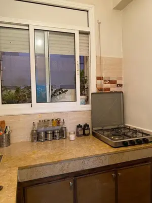 a kitchen counter with a stove and a window at Appart propre et bien situé d in Fès