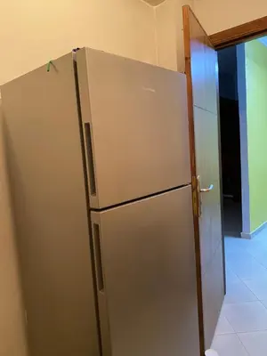 a stainless steel refrigerator next to a door at Appart propre et bien situé d in Fès