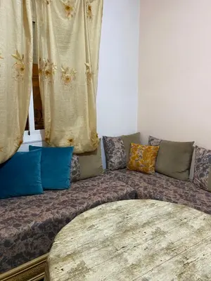 a couch with colorful pillows sitting in a room at Appart propre et bien situé d in Fès