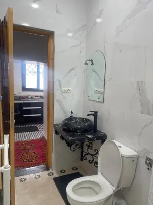 a white bathroom with a toilet and a sink at Studio Yasmine in Azrou