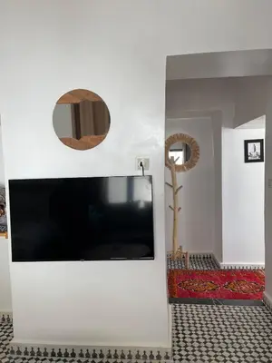 a living room with a large flat screen tv on a wall at Studio Yasmine in Azrou