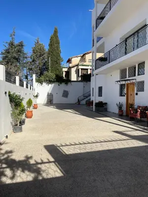 an empty courtyard of a white building with plants at Studio Yasmine in Azrou