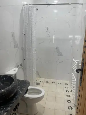a white bathroom with a toilet and a shower at Studio Yasmine in Azrou