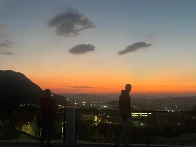 two people standing on a balcony watching the sunset at Studio Yasmine in Azrou