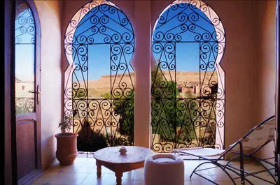 a room with two large doors with a table in front at Kasbah Titrit & Spa in Aït Ben Haddou