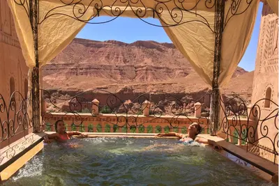 two people in a hot tub with a view of the desert at Kasbah Titrit & Spa in Aït Ben Haddou