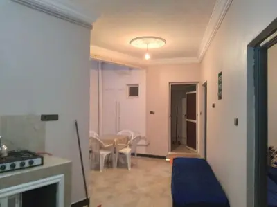 a living room with a fireplace and a table and chairs at Appartement centre ville de Tinghir in Tinerhir