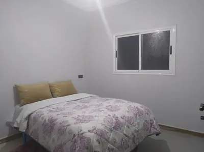 a bed in a white room with a window at Appartement centre ville de Tinghir in Tinerhir