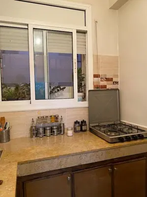 a kitchen counter with a stove and a window at Appart propre et bien situé in Fès