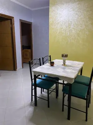 a table with four chairs and a white table and a table and chairs at Appart propre et bien situé in Fès