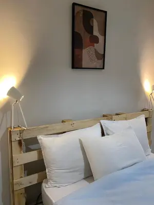 a bed with white pillows and a picture on the wall at Appart propre et bien situé in Fès