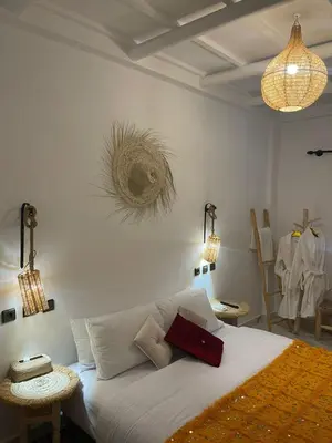a bedroom with a bed with two tables and two lights at Rose Garden Dades in Kalaat MGouna