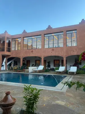 a large building with a swimming pool in front of it at Rose Garden Dades in Kalaat MGouna